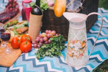 Doğada yakın çekim piknik. Sürahi ve gıda - yeşillik, domates, grap