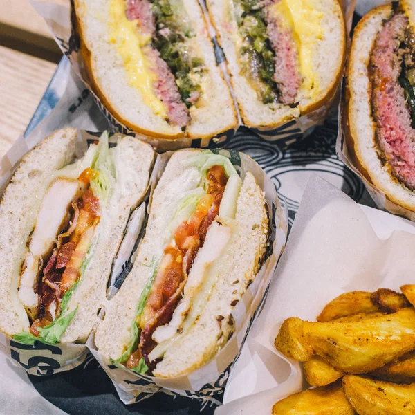 Hamburguesas de carne cortadas de cerca y papas fritas en una bandeja en un café — Foto de Stock