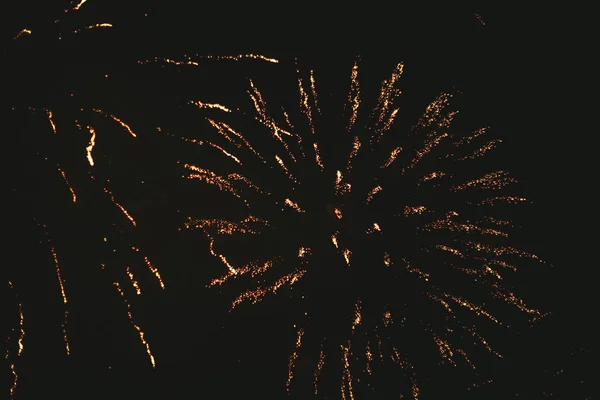 Fogos de artifício festivos de ouro close-up em um fundo preto. Abstrato — Fotografia de Stock