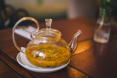 Üzerinde deniz dikeni çayı ile yakın çekim şeffaf cam çaydanlık 