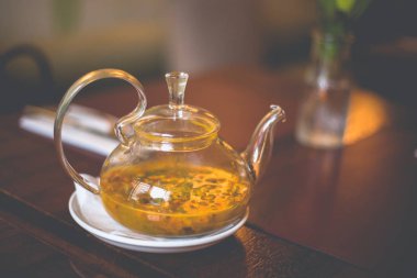 Üzerinde deniz dikeni çayı ile yakın çekim şeffaf cam çaydanlık 