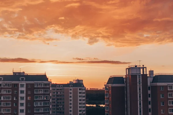 Orange-red sunset with clouds in summer with residential buildin — Stock Photo, Image