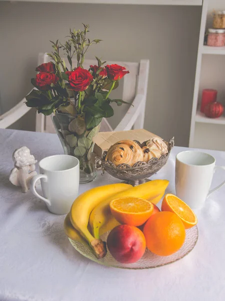 Platos de primer plano sobre la mesa: tazas, fruta, plátanos, oran — Foto de Stock