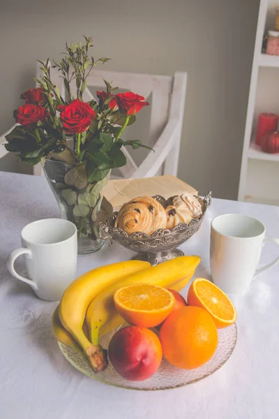 Platos de primer plano sobre la mesa: tazas, fruta, plátanos, oran — Foto de Stock