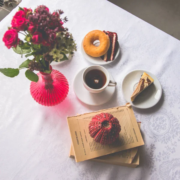 Primer plano que sirve platos en la mesa: té, donut, un pedazo de cak — Foto de Stock