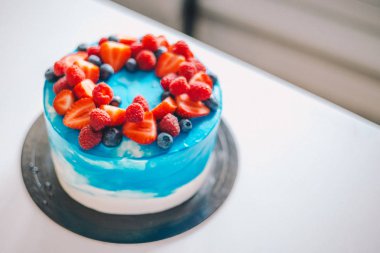 Meyvelerile süslenmiş yakın çekim şenlikli mavi ve beyaz kek: stra
