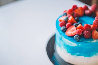 Meyvelerile süslenmiş yakın çekim şenlikli mavi ve beyaz kek: stra
