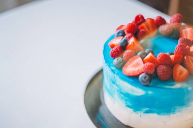 Meyvelerile süslenmiş yakın çekim şenlikli mavi ve beyaz kek: stra