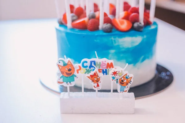 Un gros plan d'un gâteau bleu et blanc festif avec des bougies avec th — Photo