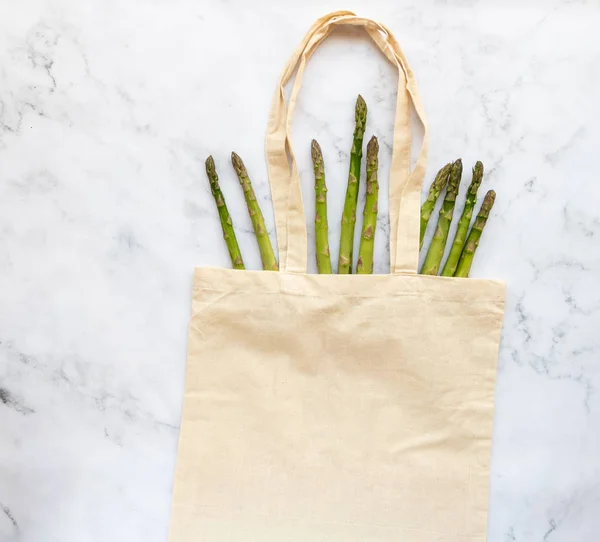 Reusable fabric bag for products with asparagus. The concept of a healthy lifestyle and environmental protection. Using fabric bags reducing the consumption of plastic bags.