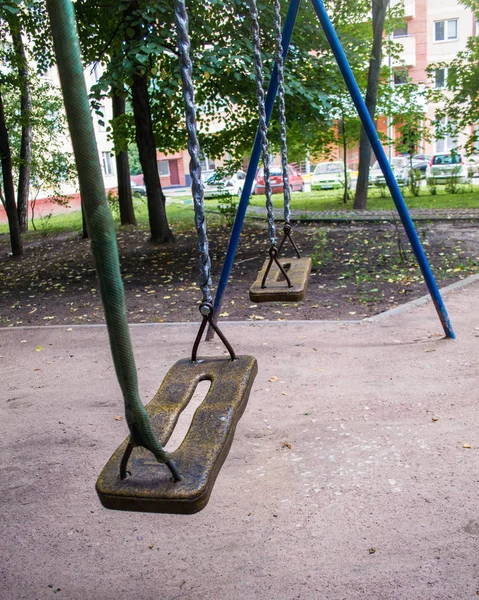 Bahçede çocuklar için zincirler üzerinde ahşap salıncaklar