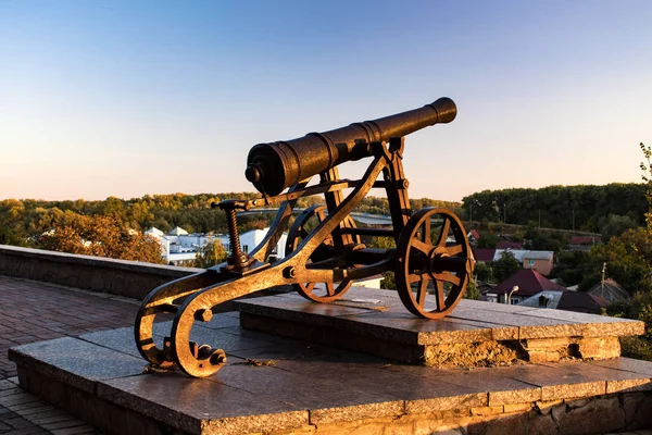 Summer or early autumn park at sunset. Ancient cast iron cannon