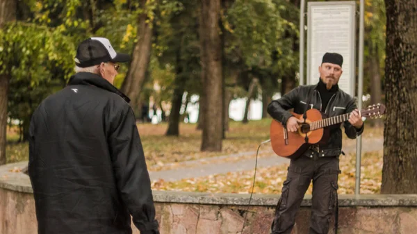 Gün batımında yaz veya erken sonbahar parkında yürüyen insanlar