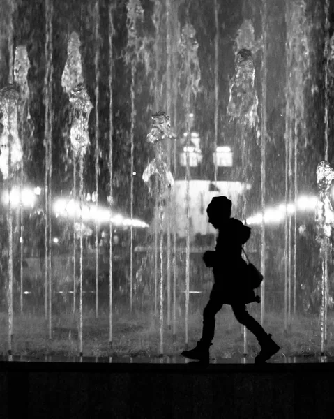 Çeşme sınırında yürüyen küçük bir kız çocuğu. Siyah ve beyaz siluet olarak biçimlendirilmiş