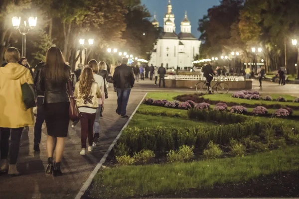 Akşamları yaz veya erken sonbahar parkında yürüyen insanlar