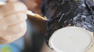 Kadın sanatçı vernik siyah boyalı el bir fırça ve lake ile kova yapılmış