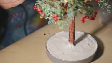 Kadın sanatçı vernik işlemi öncesi el yapımı tel ağacı boyama