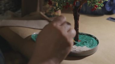 Kadın sanatçı vernik işlemi öncesi el yapımı tel ağacı boyama