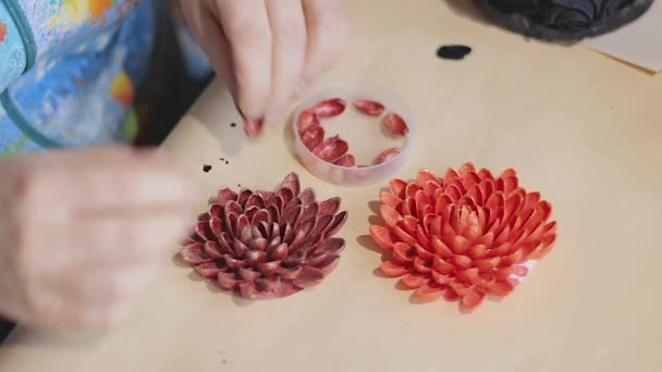 女性アーティストは 明るい塗装ナットシェルで装飾的な花のデザインを作っています — ストック動画