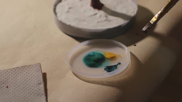 女性アーティストはワニスプロセスの前に手作りのワイヤーツリーを塗装しています — ストック動画