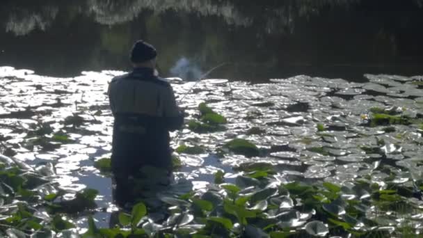 Pescador lanzando la caña de pescar en el agua — Vídeo de stock