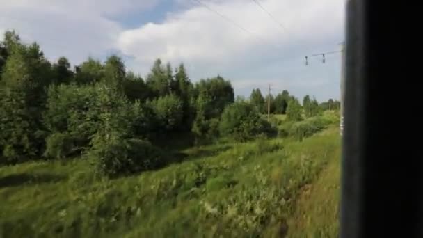 Nagrywanie widoków przez okno poruszającego się pociągu podmiejskiego latem — Wideo stockowe