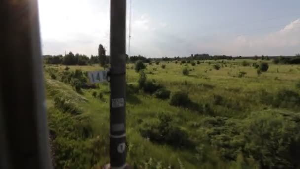Filmación de la vista a través de la ventana del tren suburbano en movimiento en verano — Vídeos de Stock