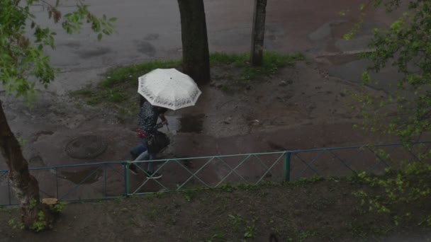 Люди, що йдуть на тротуарі під дощем — стокове відео