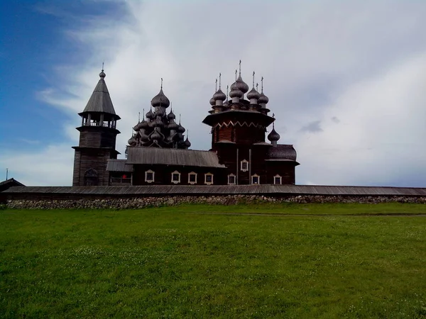 View of Kizhi Island, the historic site of churches and bell tower, a large historic log wood house on the marshy banks of island. — Stock Photo, Image