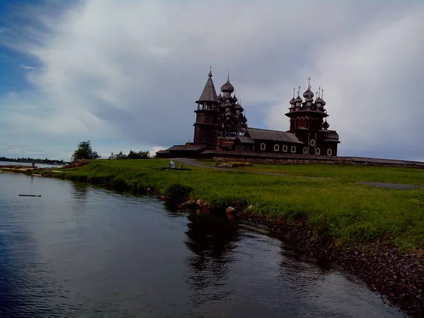 Blick auf die Insel Kizhi, die historische Stätte von Kirchen und Glockenturm, ein großes historisches Blockhaus am sumpfigen Ufer der Insel. — Stockfoto