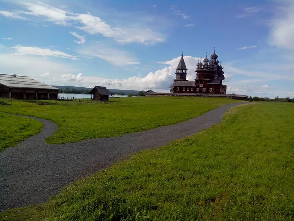 Kizhi Island, a történelmi helyszínen, az egyházak és a bell tower, egy nagy történelmi fa ház mocsaras sziget partján. — Stock Fotó