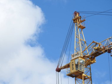 Büyük inşaat alanında, birkaç da dahil olmak üzere karmaşık bir açık mavi gökyüzü inşaat üzerinde çalışmaya vinç.