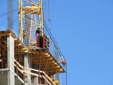 Büyük inşaat alanında, birkaç da dahil olmak üzere karmaşık bir açık mavi gökyüzü inşaat üzerinde çalışmaya vinç.