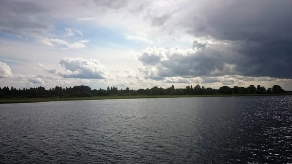 Cielo blu e lago blu in estate. Nuvole bianche si riflettono nell'acqua. Il famoso lago Seliger. Russia . — Foto Stock