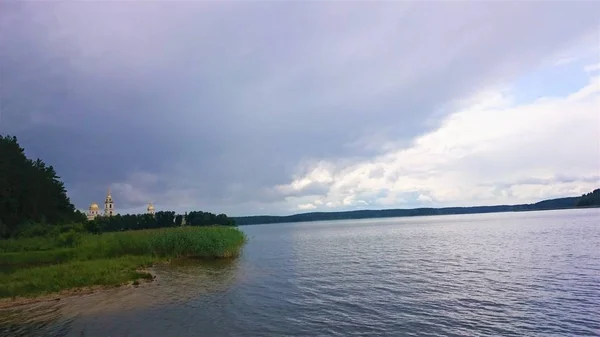 青い空と夏の青い湖。白い雲は、水に反映されます。有名なセリゲル湖。ロシア. — ストック写真