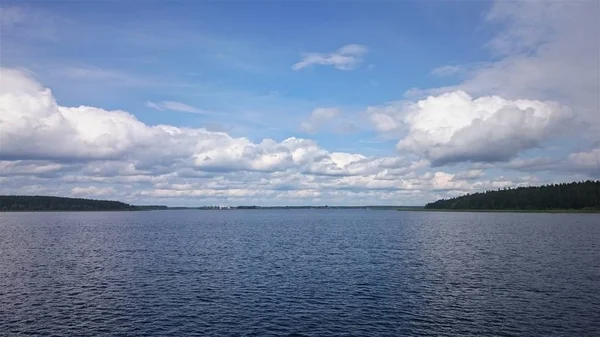 Γαλάζιο ουρανό και γαλάζια λίμνη το καλοκαίρι. Λευκά σύννεφα αντικατοπτρίζεται στο νερό. Η περίφημη Βασιλική του Αγίου Πέτρου. Ρωσία. — Φωτογραφία Αρχείου