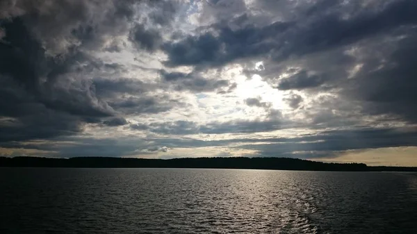 Синє небо та синє озеро влітку. Білі хмари відбиваються у воді. Знаменитий Селігер озера. Росія. — стокове фото