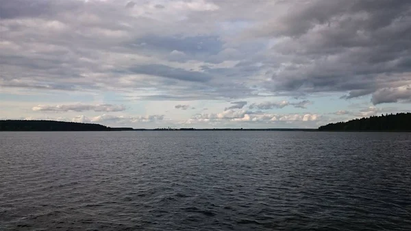 Cielo blu e lago blu in estate. Nuvole bianche si riflettono nell'acqua. Il famoso lago Seliger. Russia . — Foto Stock