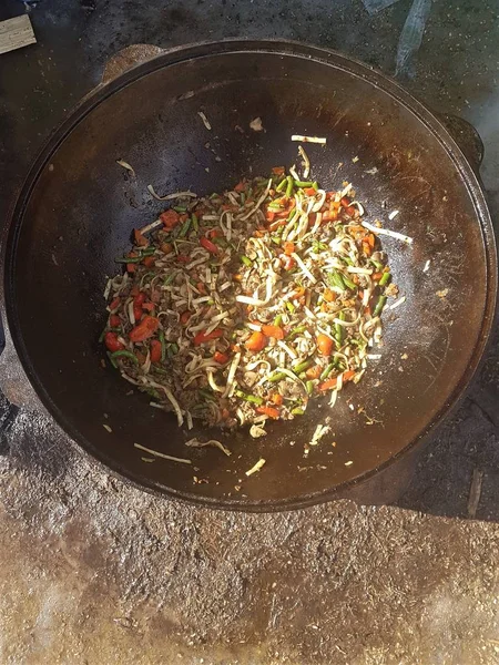 Centraal Aziatische keuken - bovenaanzicht van warme gekookte pottage van lamsvlees en groenten in gietijzeren ketel — Stockfoto