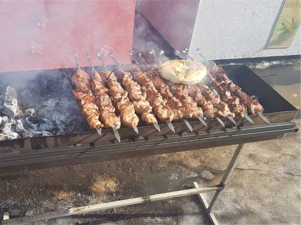 Juteux mariné dans des épices kebab de viande sur des brochettes, cuit et frit sur un barbecue au feu et au charbon de bois, dans la nature de l'hiver enneigé, par temps clair — Photo