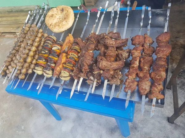 Juicy marinated in spices meat kebab on skewers, cooked and fried on a fire and charcoal barbecue grill, in the nature of snowy winter, on a clear day — Stock Photo, Image