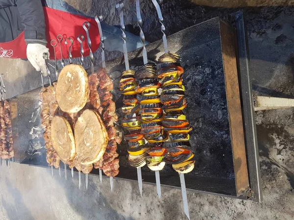 Juteux mariné dans des épices kebab de viande sur des brochettes, cuit et frit sur un barbecue au feu et au charbon de bois, dans la nature de l'hiver enneigé, par temps clair — Photo