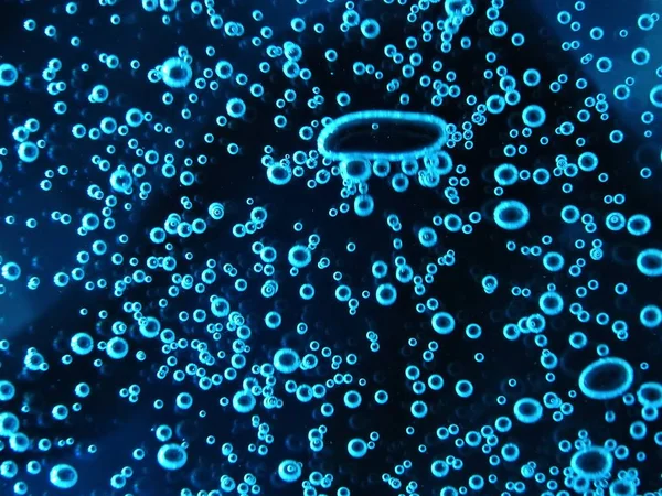 Zár - up légbuborékok a különböző színek, vízben elszigetelt sötét háttér — Stock Fotó
