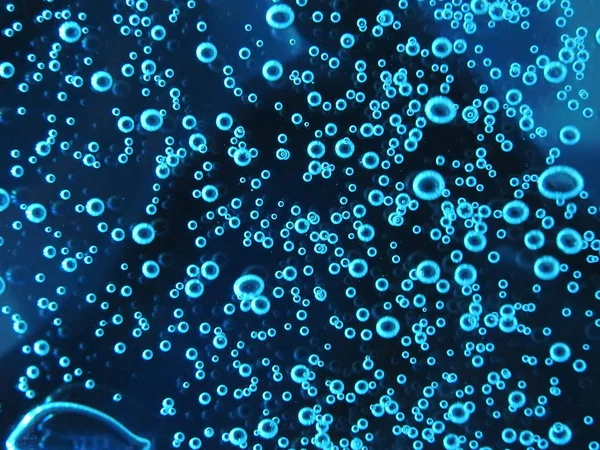 Close - up of air bubbles of different colors, in water isolated on dark background — Stock Photo, Image