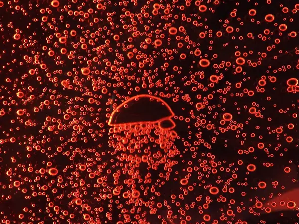 Close - up of air bubbles of different colors, in water isolated on dark background — Stock Photo, Image