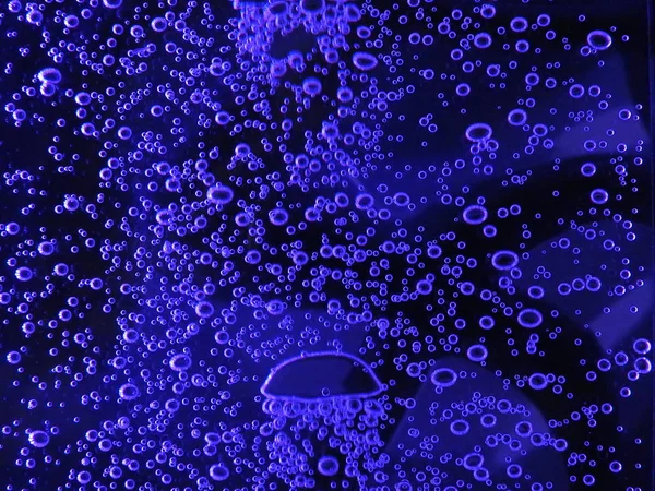 Close - up of air bubbles of different colors, in water isolated on dark background — Stock Photo, Image