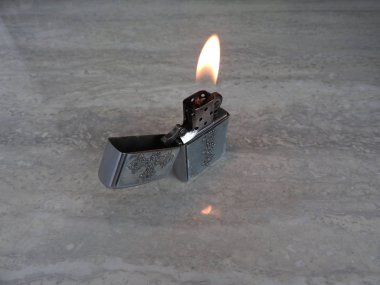 metal çakmak açık alev üzerinde siyah arka plan ile.