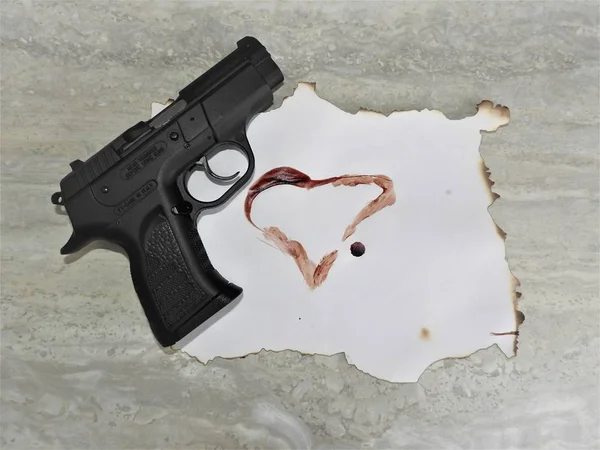 Pistola tanfoglio brutal negro con cámara para 9mm y sangre al corazón . —  Fotos de Stock