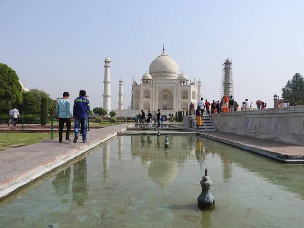 La chica en el sombrero por detrás mira el Mausoleo Taj Mahal, un símbolo de amor, mármol blanco en la orilla sur del río Yamuna en la ciudad india de Agra, Uttar Pradesh . — Foto de Stock