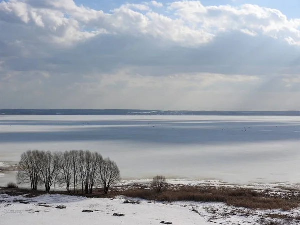 Ghiaccio lago ghiacciato in una giornata invernale soleggiata in Russia. Neve bianca e nuvole nel cielo blu. Bellissimo paesaggio invernale . — Foto Stock